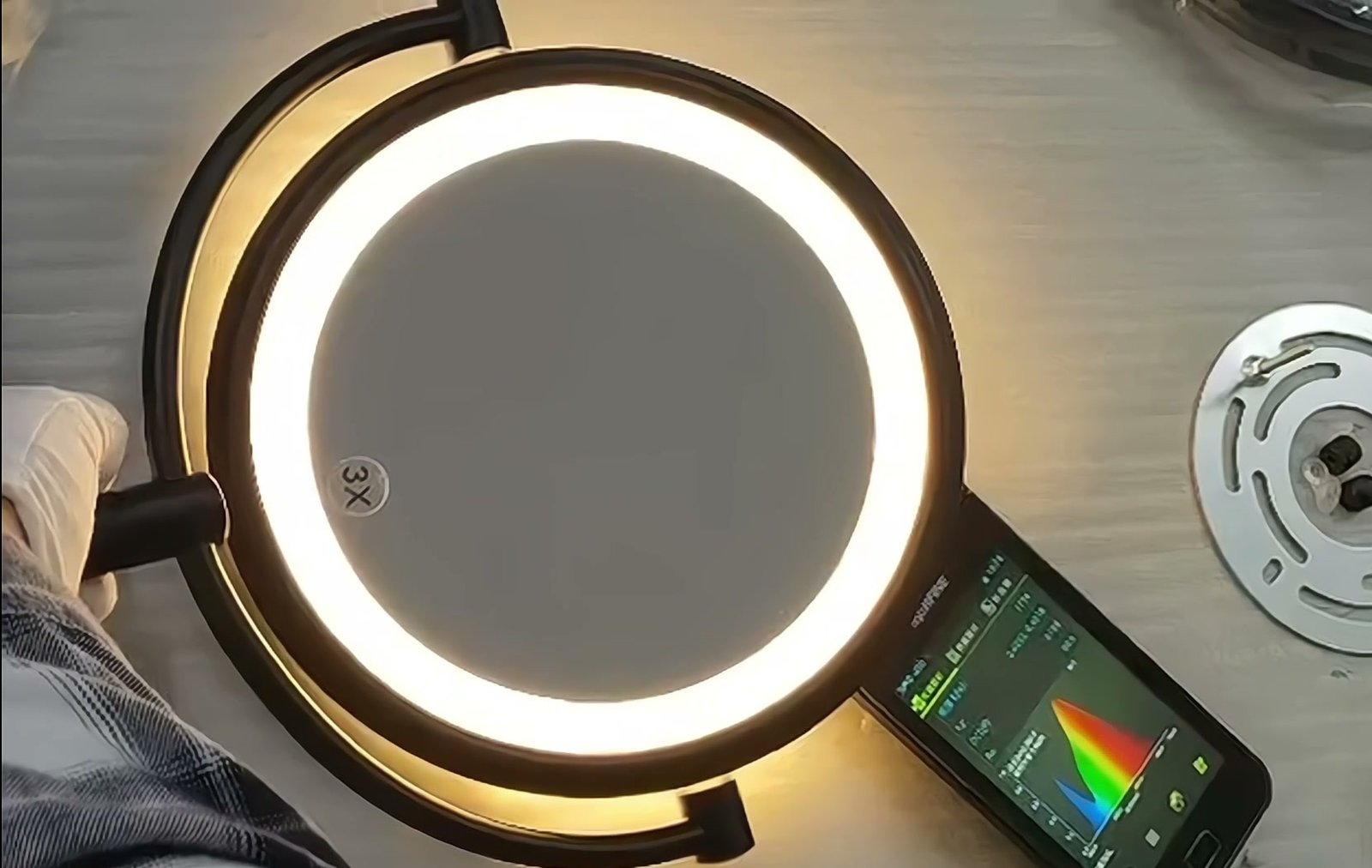 Illuminated round LED makeup mirror undergoing spectrometer light testing in the factory