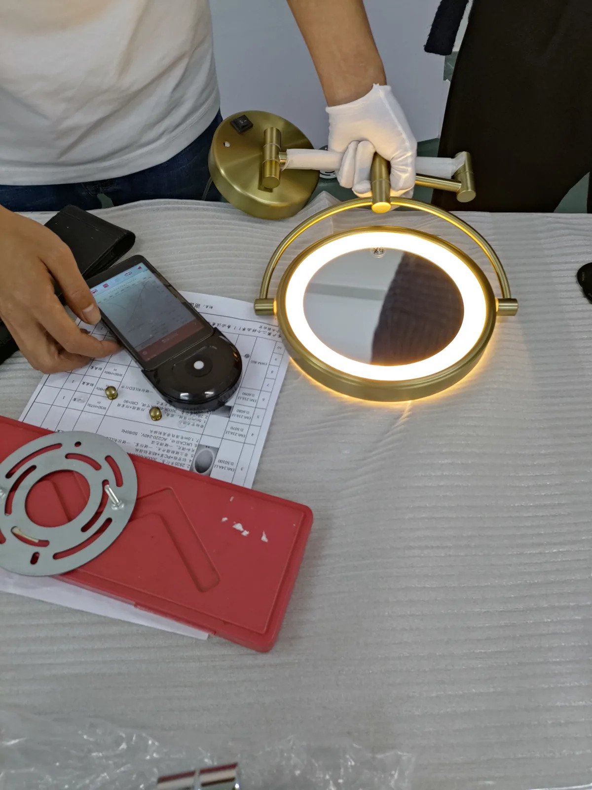 Technician testing an illuminated swing-arm extendable LED makeup mirror in the factory